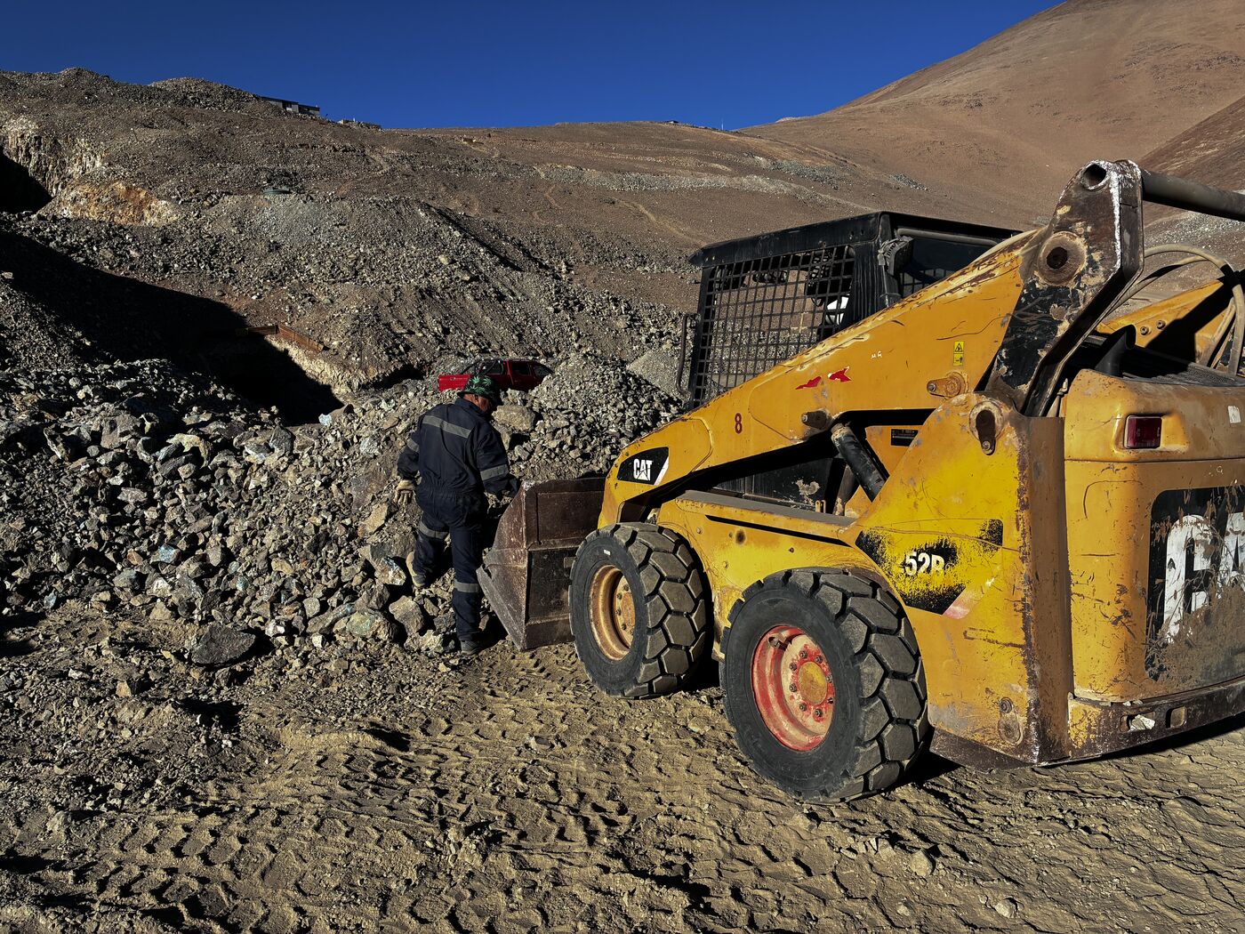 Carguío de mineral con minicargador CAT en superficie, faena minera en la Región de Atacama