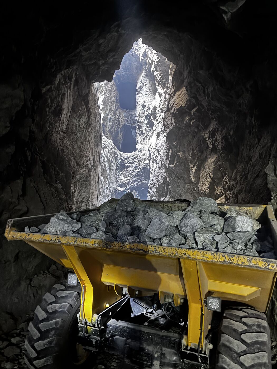 Dumper cargado con mineral en labor subterránea, bajo chimenea de realce